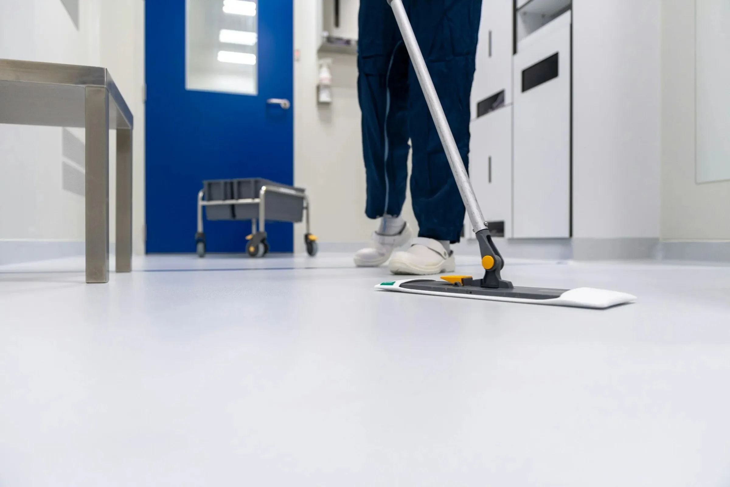 ABC Cleaning technician mopping a clean room floor in a controlled environment